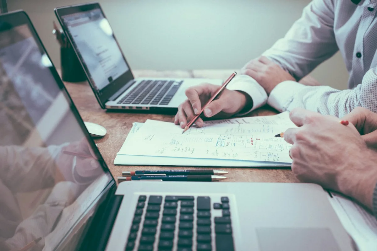 Personas revisando documentos junto a un ordenador
