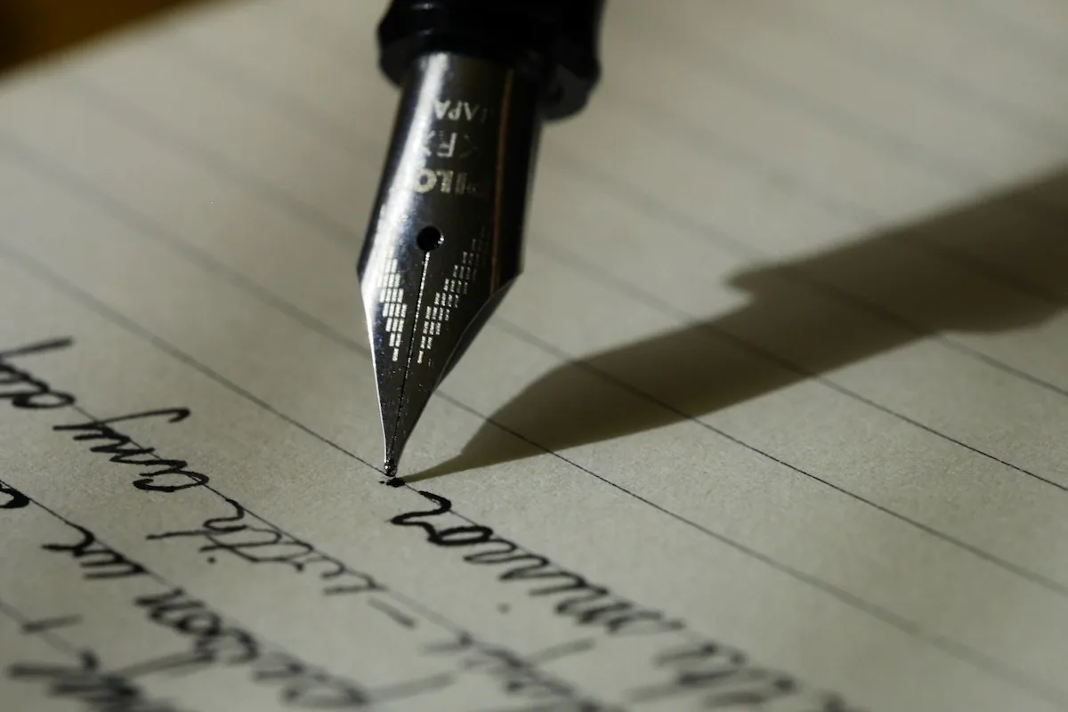 Pluma sobre un cuaderno con texto manuscrito